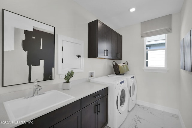 washroom featuring separate washer and dryer, sink, and cabinets