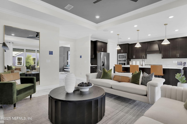 living room featuring crown molding, ceiling fan, and a tray ceiling