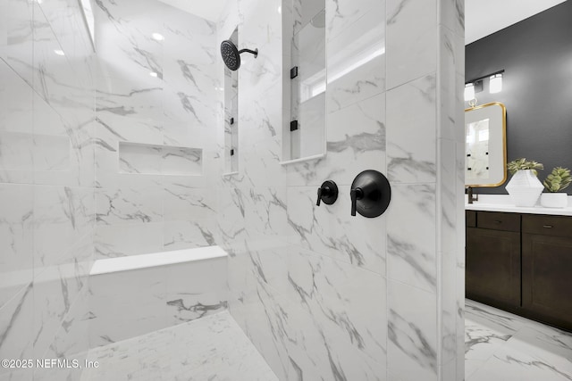 bathroom with a tile shower and vanity