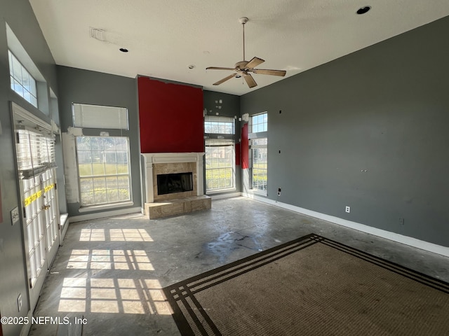 unfurnished living room with ceiling fan, concrete floors, and a textured ceiling