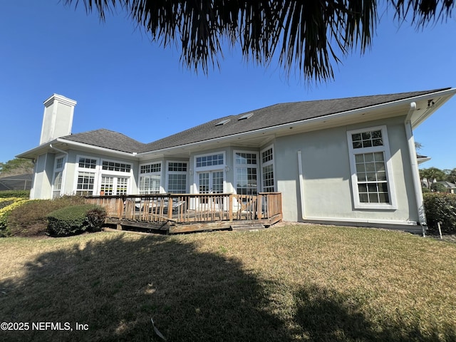 rear view of house with a wooden deck and a yard