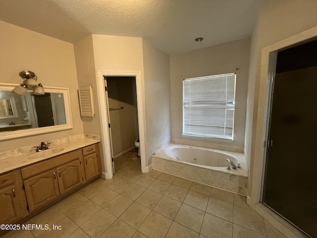 bathroom with toilet, a textured ceiling, vanity, a tub, and tile patterned flooring