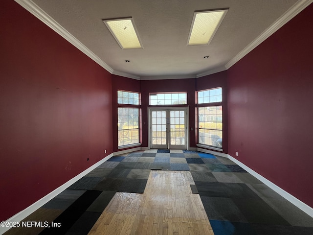 spare room with hardwood / wood-style flooring, crown molding, and french doors