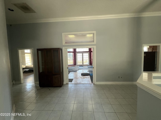 tiled empty room featuring ornamental molding