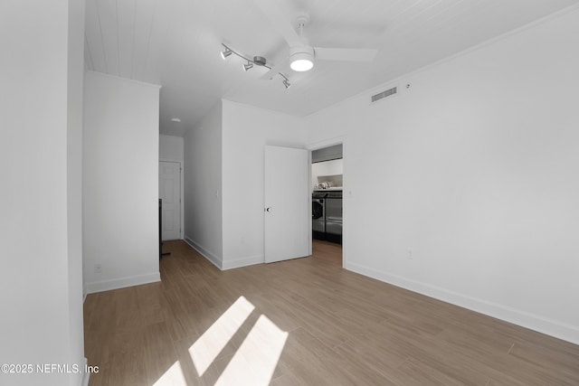 unfurnished bedroom with a closet, a spacious closet, ceiling fan, and light hardwood / wood-style flooring