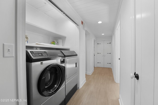 laundry area with light hardwood / wood-style floors and independent washer and dryer