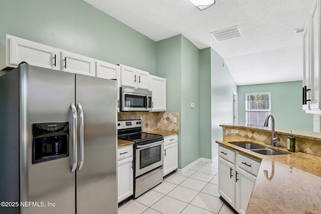 kitchen with stainless steel appliances, white cabinetry, sink, and decorative backsplash