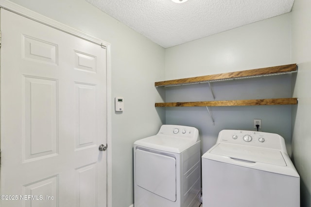 laundry area featuring washer and clothes dryer and a textured ceiling