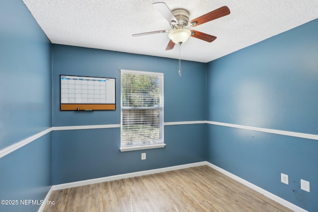 spare room with ceiling fan, light hardwood / wood-style flooring, and a textured ceiling