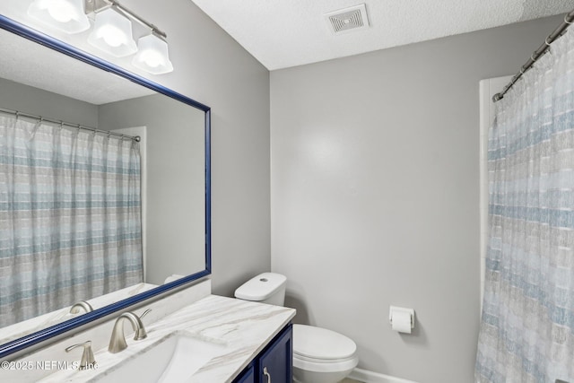 bathroom featuring vanity, toilet, and a textured ceiling