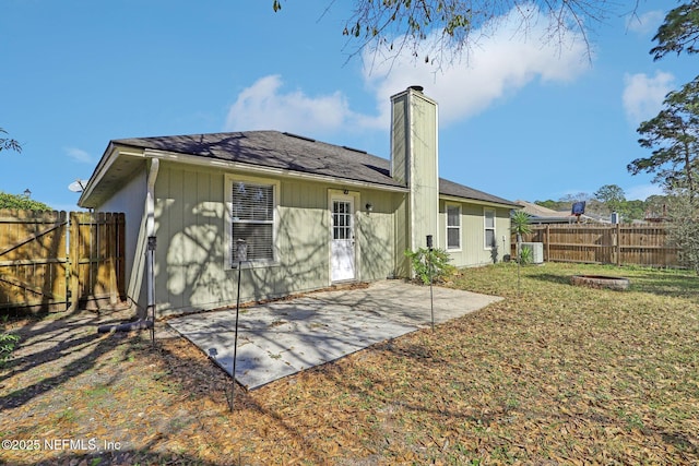 back of property with a patio area, central air condition unit, and a lawn