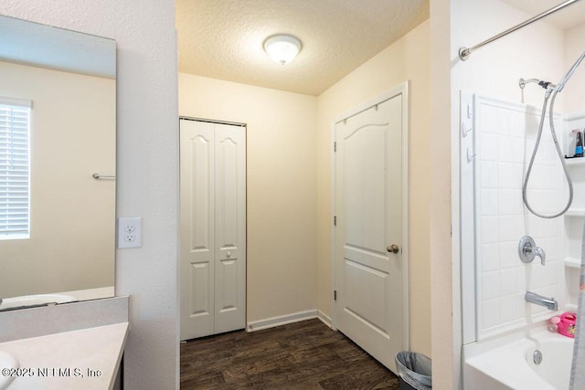 bathroom with hardwood / wood-style flooring, vanity, bathing tub / shower combination, and a textured ceiling