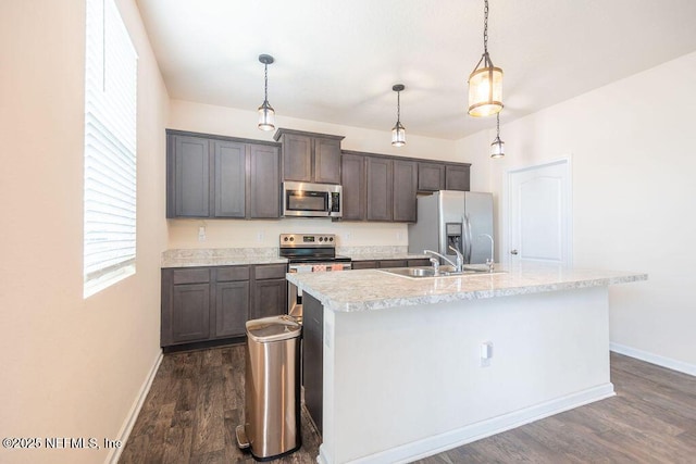 kitchen featuring stainless steel appliances, an island with sink, pendant lighting, and dark hardwood / wood-style flooring