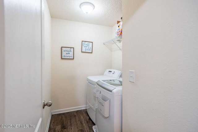 laundry room with dark hardwood / wood-style flooring, a textured ceiling, and washer and clothes dryer