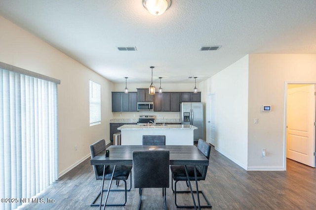 dining space featuring dark hardwood / wood-style floors, sink, and a textured ceiling