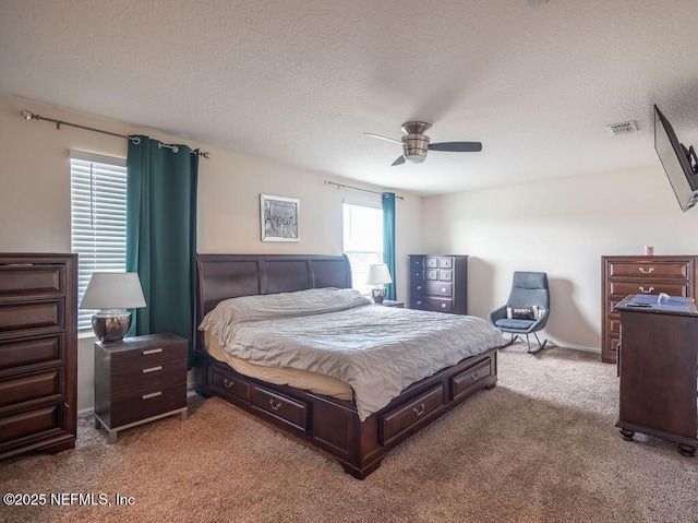 bedroom with ceiling fan, carpet, and a textured ceiling