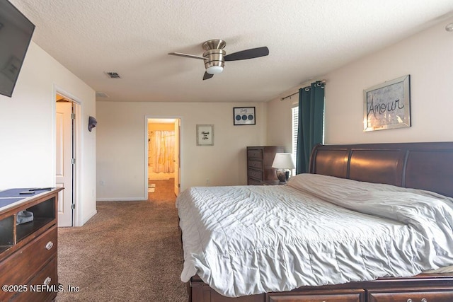 bedroom with ceiling fan, ensuite bathroom, a textured ceiling, and carpet