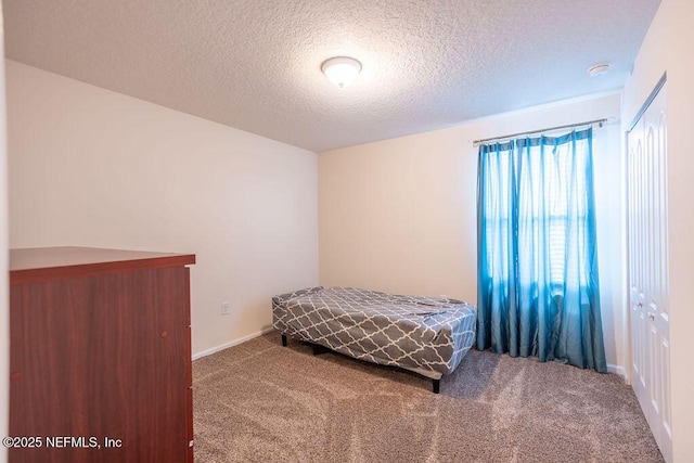 unfurnished bedroom with carpet, a textured ceiling, and a closet