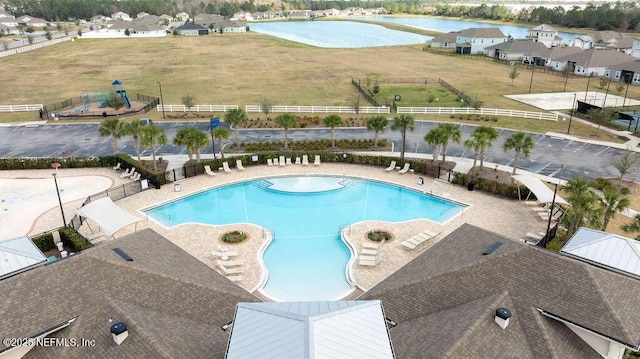 view of swimming pool with a water view and a patio area