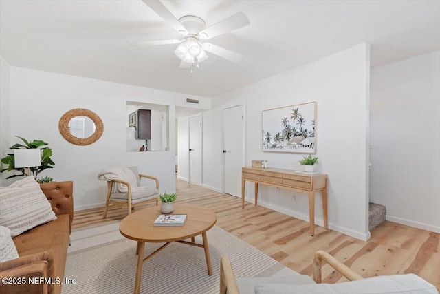 living room with wood-type flooring and ceiling fan