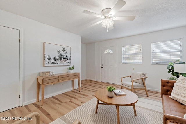 living room with hardwood / wood-style flooring, ceiling fan, and a textured ceiling