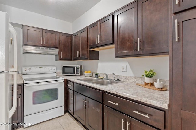 kitchen featuring dark brown cabinets, sink, light tile patterned floors, and white appliances