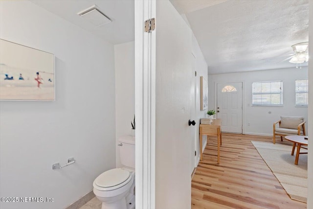 bathroom featuring hardwood / wood-style floors, a textured ceiling, and toilet