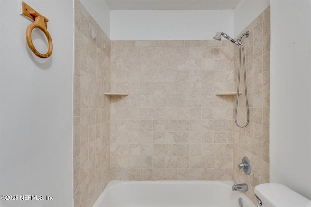 bathroom featuring toilet and tiled shower / bath combo