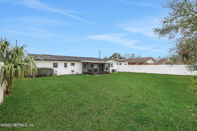 rear view of property featuring a sunroom and a lawn