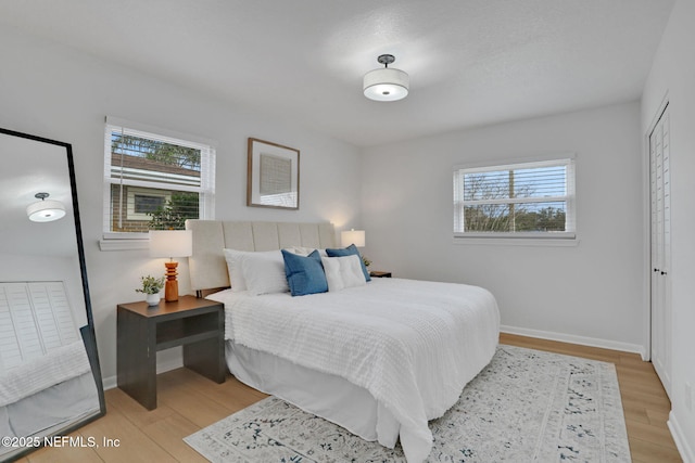 bedroom featuring multiple windows and light wood-type flooring