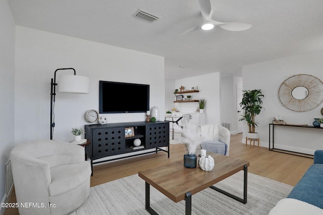 living room with ceiling fan and light hardwood / wood-style floors