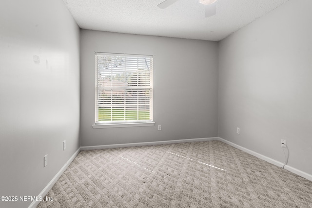 carpeted empty room with ceiling fan and a textured ceiling