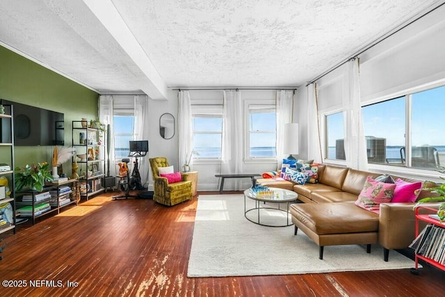 living room featuring a water view, hardwood / wood-style floors, and a textured ceiling