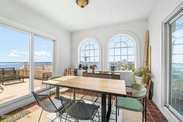 sunroom featuring a water view and plenty of natural light