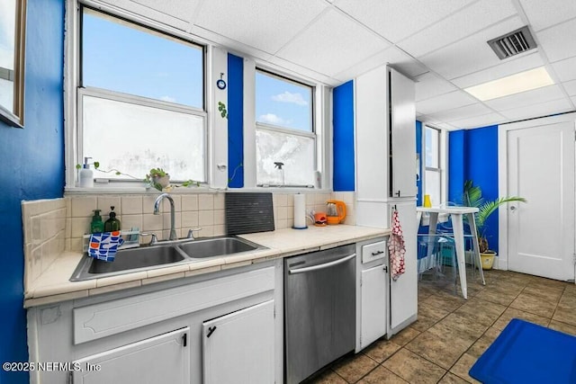 kitchen with dishwasher, sink, a paneled ceiling, and white cabinets