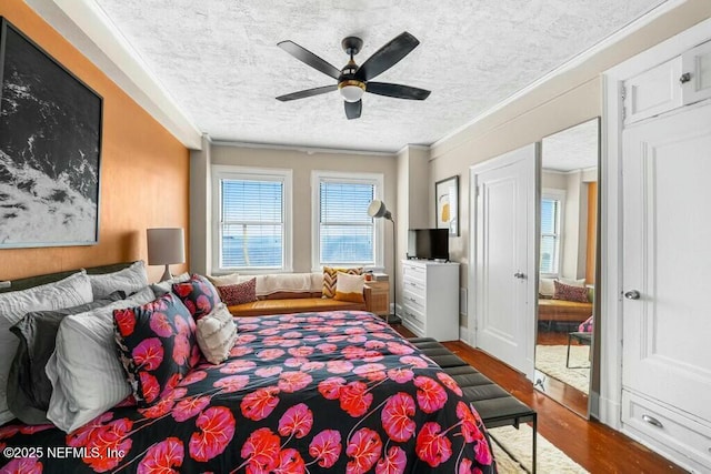 bedroom with dark hardwood / wood-style flooring, ceiling fan, crown molding, and a textured ceiling