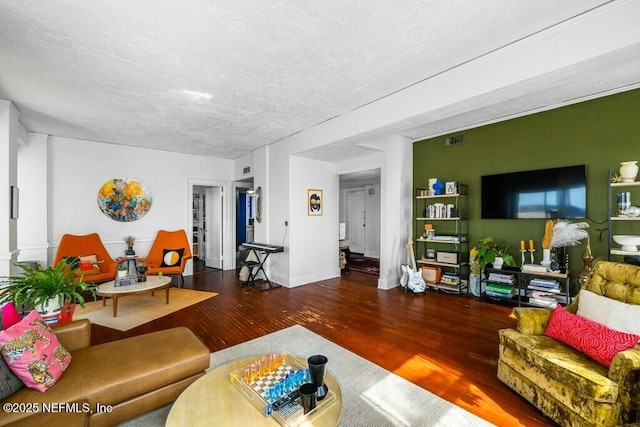 living room with dark hardwood / wood-style floors and a textured ceiling