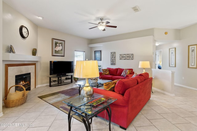 living room featuring light tile patterned floors, a fireplace, and ceiling fan