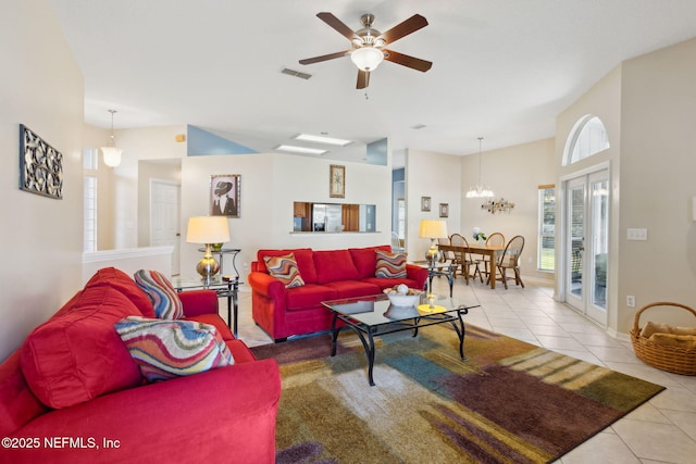 tiled living room featuring ceiling fan with notable chandelier