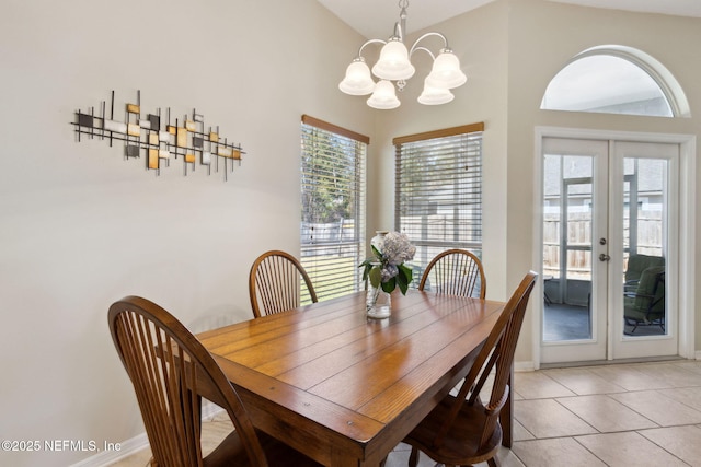 tiled dining area featuring an inviting chandelier, vaulted ceiling, and french doors