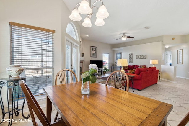 dining room featuring light tile patterned flooring and ceiling fan with notable chandelier