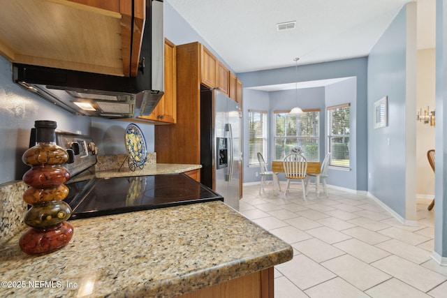 kitchen with light tile patterned flooring, electric range oven, stainless steel fridge, hanging light fixtures, and light stone countertops