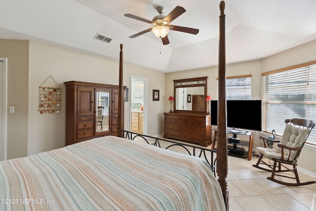 tiled bedroom featuring vaulted ceiling, ensuite bathroom, ceiling fan, and a textured ceiling