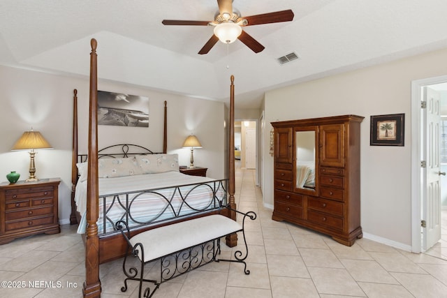 tiled bedroom featuring vaulted ceiling, ceiling fan, and a tray ceiling