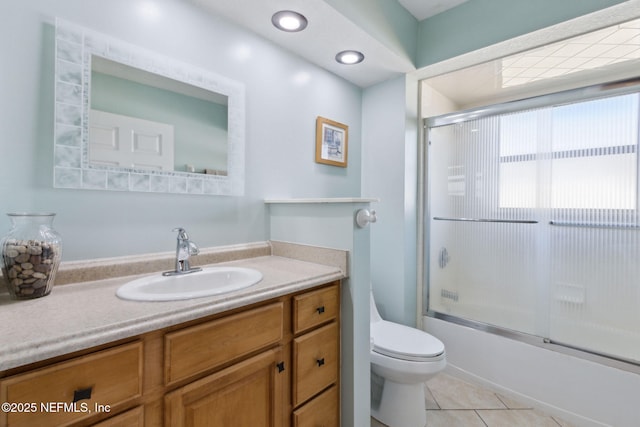 full bathroom with bath / shower combo with glass door, vanity, tile patterned floors, and toilet