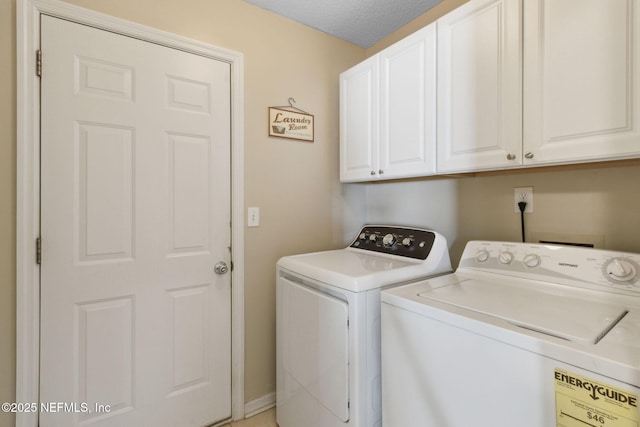 laundry area featuring cabinets, washer and clothes dryer, and a textured ceiling