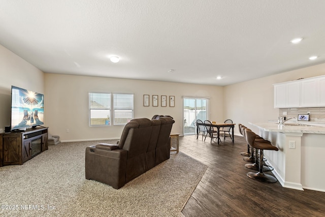 living room featuring sink, dark hardwood / wood-style floors, and a textured ceiling