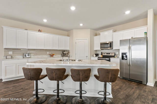 kitchen with sink, dark wood-type flooring, white cabinetry, a kitchen island with sink, and stainless steel appliances