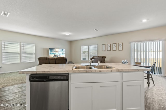 kitchen featuring stainless steel dishwasher, a kitchen island with sink, sink, and white cabinets