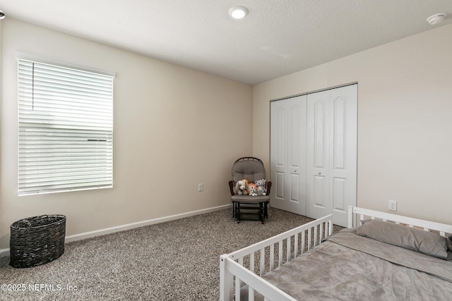 carpeted bedroom with a closet and a textured ceiling